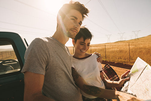 Couple on a road trip looking at map for navigation