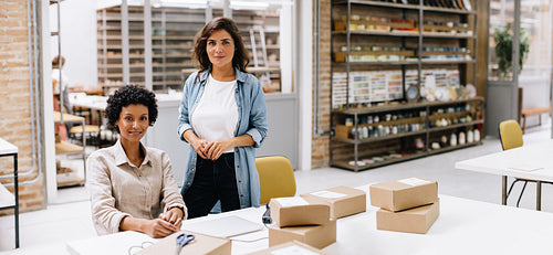Confident online store owners looking at the camera in a warehouse