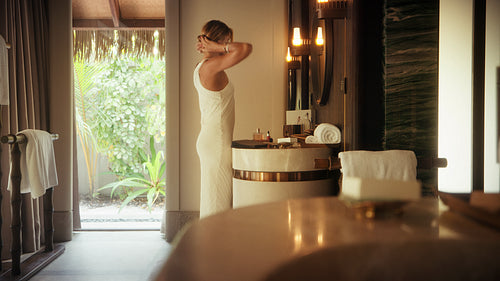 Elegant woman doing her morning skincare routine in a luxurious tropical resort villa