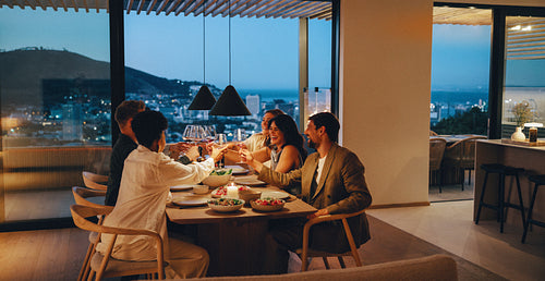Close friends enjoying a dinner sharing laughs at a home with city view