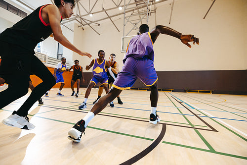 Active basketball game in a gym with focused players in action