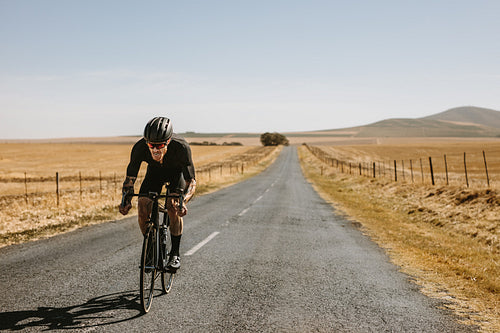 Man taking a bicycle ride on the empty road