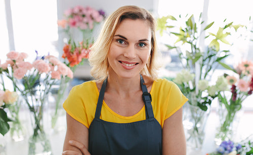 Beautiful woman florist standing in flower shop