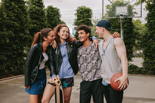 Four young friends standing together outdoors