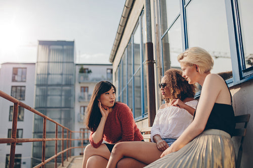 Three young women sitting outdoors and chatting
