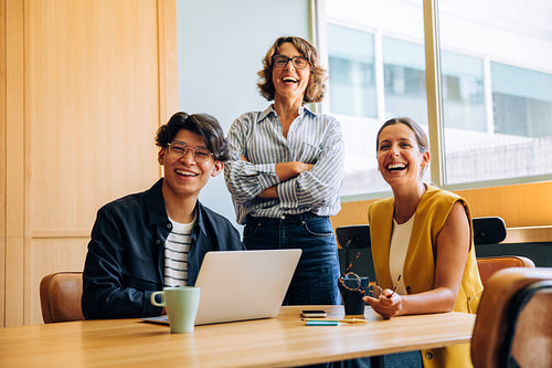 Professionals smiling and collaborating in a modern office environment