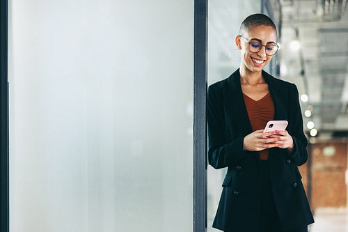 Successful businesswoman reading a text message in an office