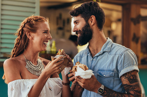 Couple enjoying eating food truck burger