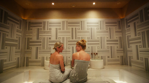Two women enjoy a relaxing conversation together in a luxurious and traditional Hammam spa