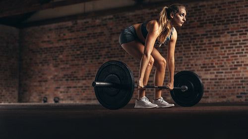Fitness woman performing weight lifting exercise at gym