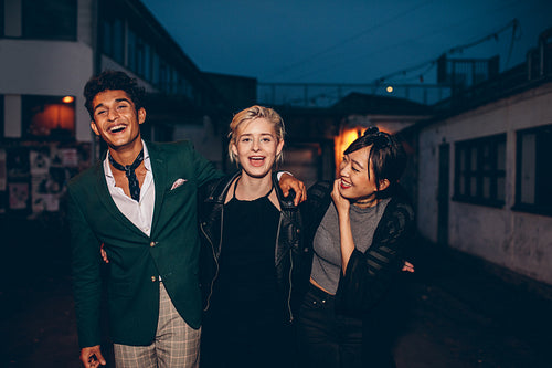 Young friends having fun on city street at night