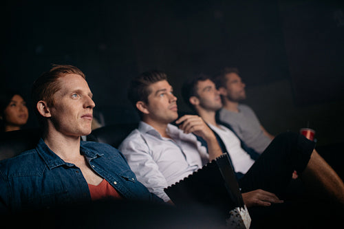 Young friends watching movie in cinema hall