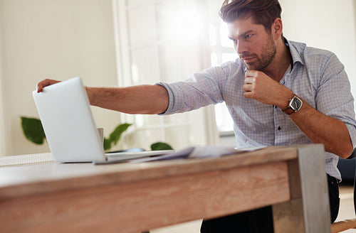 Businessman sitting at table with laptop