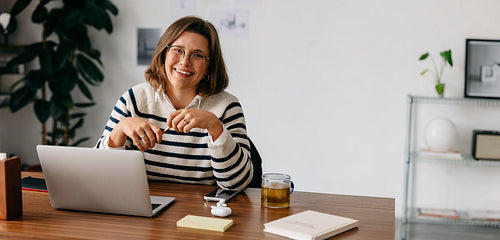 During a break, the woman stays at her laptop in a calm home office workspace