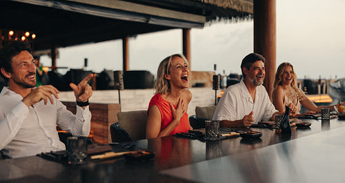 Group of adults enjoying a joyful gourmet dining experience at a resort