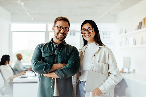 Portrait of two business people standing in an office