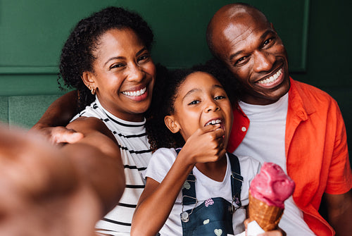 Happy black family enjoying fun ice cream time together