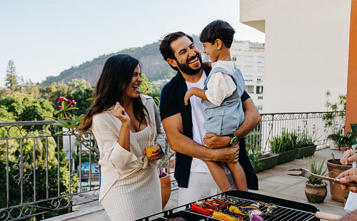 Happy family enjoying a Brazilian churrasco on a sunny patio