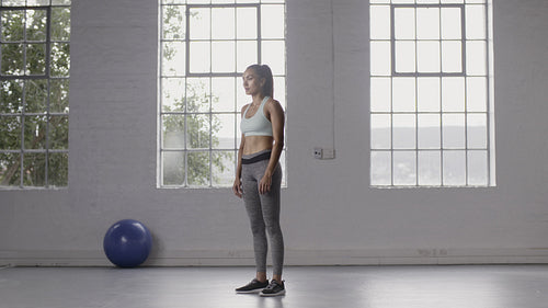 Woman doing burpee workout at fitness studio