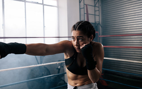 Female boxer training inside a boxing ring
