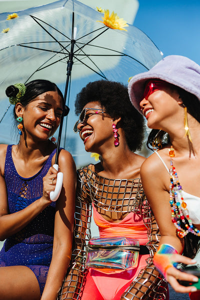 Girls celebrate under colorful carnival umbrella