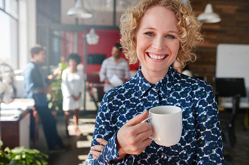 Female creative professional having a coffee in office