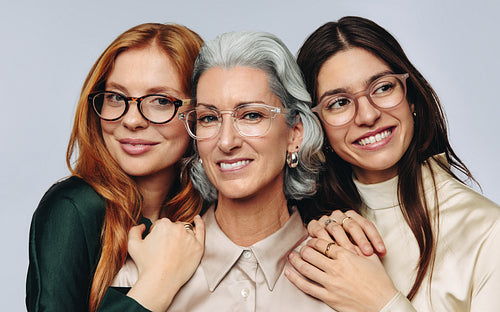 Women embrace mother and smile at camera
