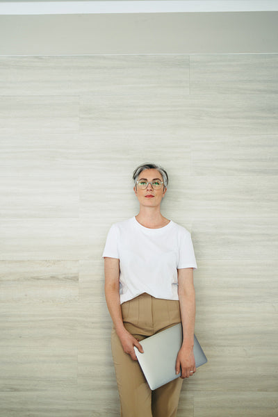 Confident businesswoman standing against a wall in an office