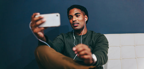 Modern businessman video calling his partners in a lobby