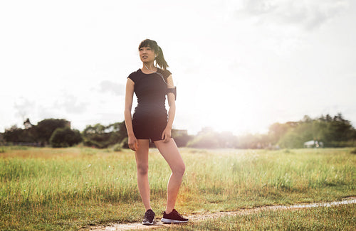 Female runner standing outdoors in morning