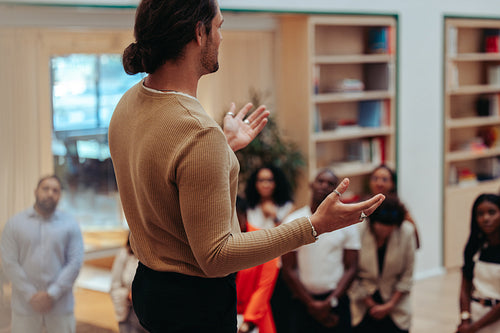 Internal meeting in a modern office setting with a speaker addressing a diverse team