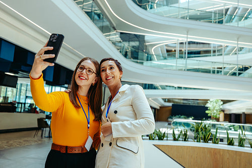 Two colleagues taking a selfie in a next-generation workplace