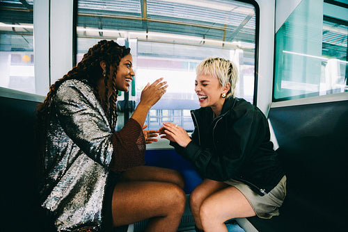 Friends laugh together while riding the metro