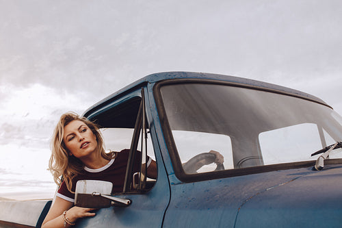 Woman traveling by a old truck