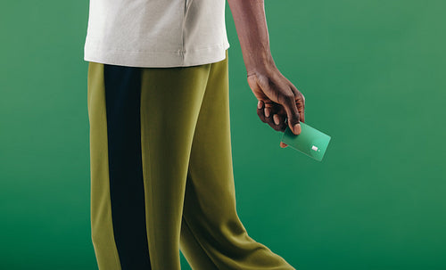 Going cashless, young man walks with his contactless credit card in his hand