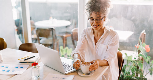 Cheerful businesswoman having coffee in a cafe