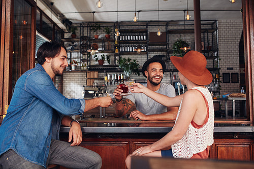 Young friends at cafe toasting drinks