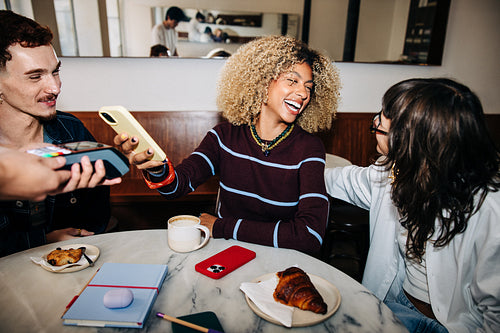 Friends in a cafe making a contactless payment