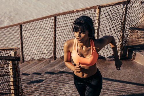 Woman running up on seaside stairway