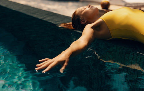 Relaxed woman enjoying a luxurious resort poolside retreat