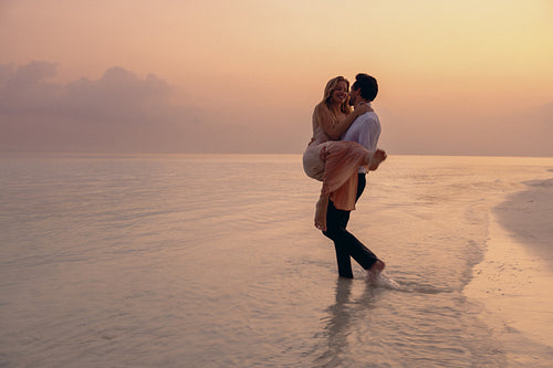 Newlyweds enjoying a romantic elopement on a secluded island at sunset