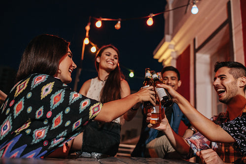 Young people at party toasting beers