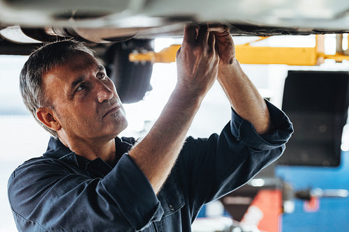 Auto mechanic fixing a car in service station