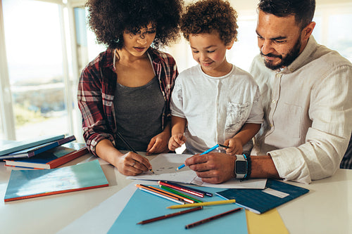 Couple teaching a kid to write and draw
