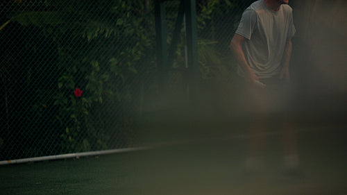 Adult man playing tennis vigorously on an outdoor court, enjoying the sport and staying active