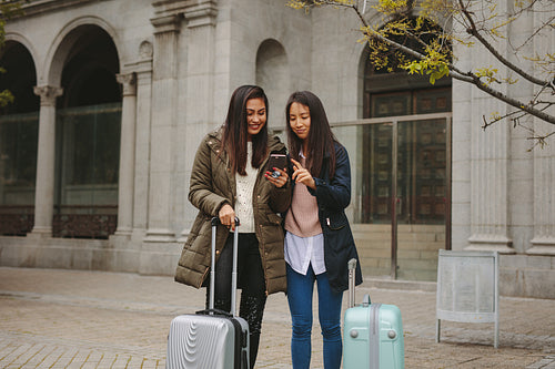 Female tourists looking at their mobile phone for navigation