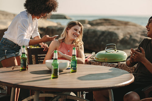 Group of friends on a vacation enjoying at a beachside table