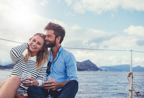 Affectionate couple on the deck of a yacht and having wine