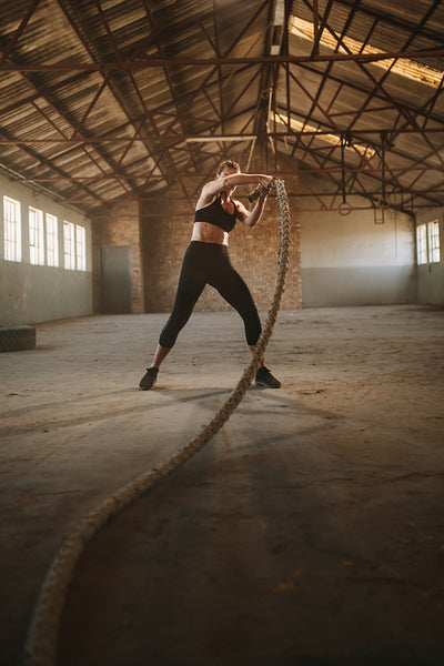 Strong woman using training ropes for exercise