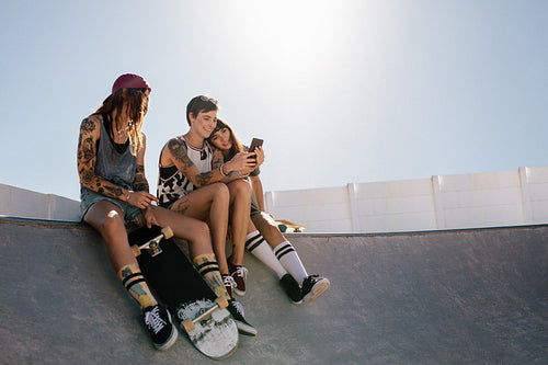 Female skaters using smart phone at skate park